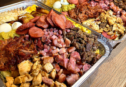 Salchicausa cargada con los 13 toppings: carne, pollo, pulled pork, bacon, chuleta de sajonia, salchicha, huevo de codorniz, guacamole, cheddar, mozzarella, maíz, tajadas y piña